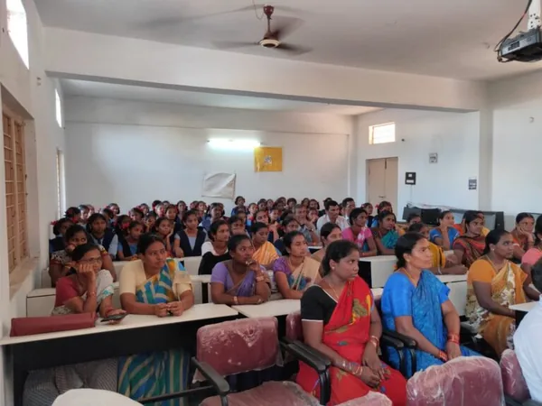 An audience seated in rows in a bright meeting room.